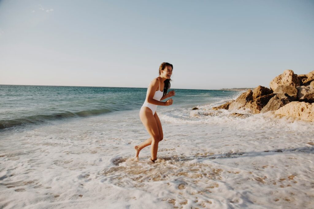 woman with hollywood bikini wax laughing at the beach